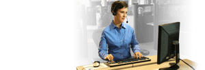 Relay operator wearing a headset working at her computer.