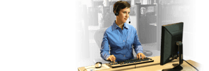 Relay operator wearing a headset working at her computer.